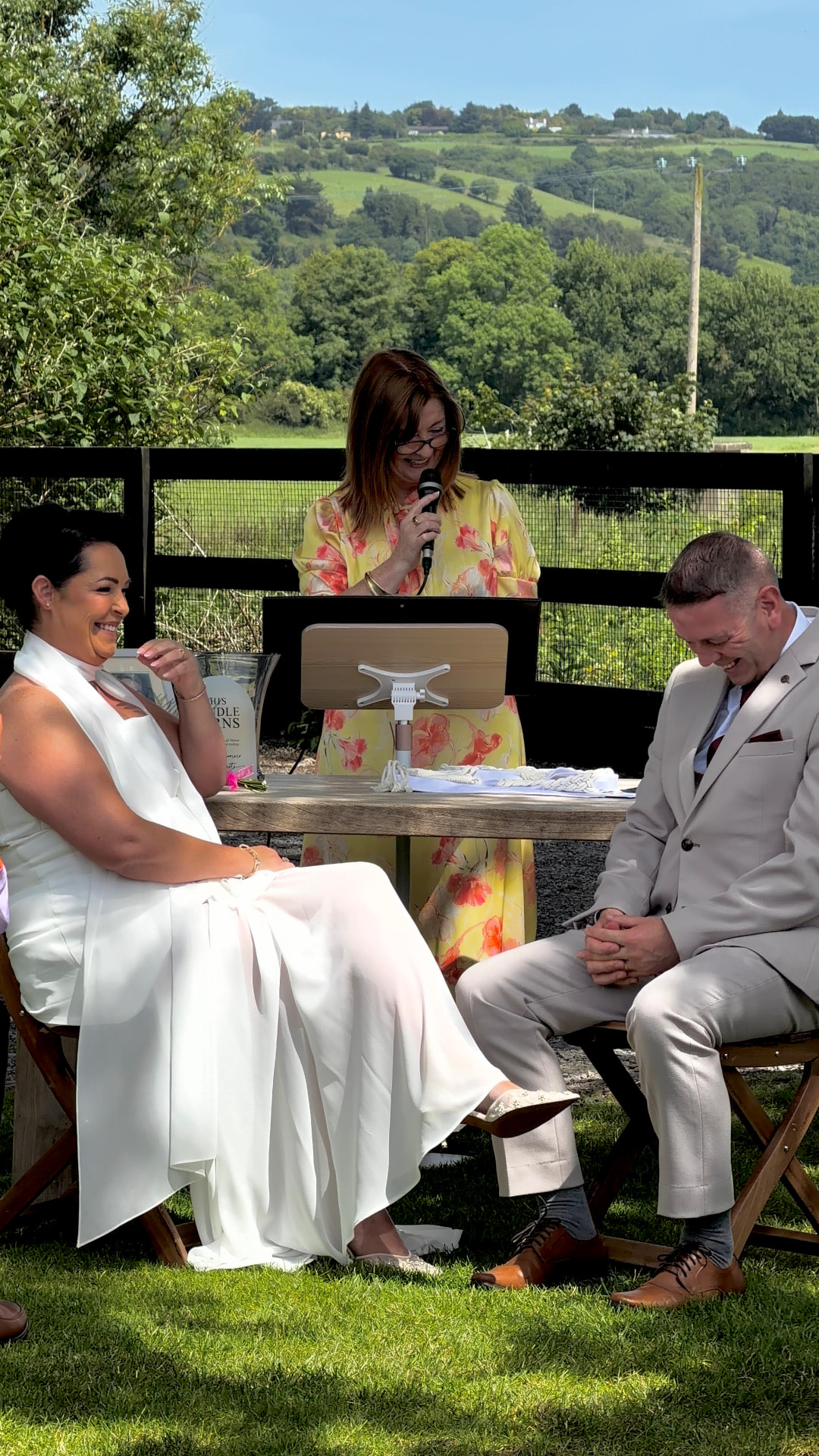 Yvonne and Trevor laughing during their outdoor ceremony at Anglers Rest