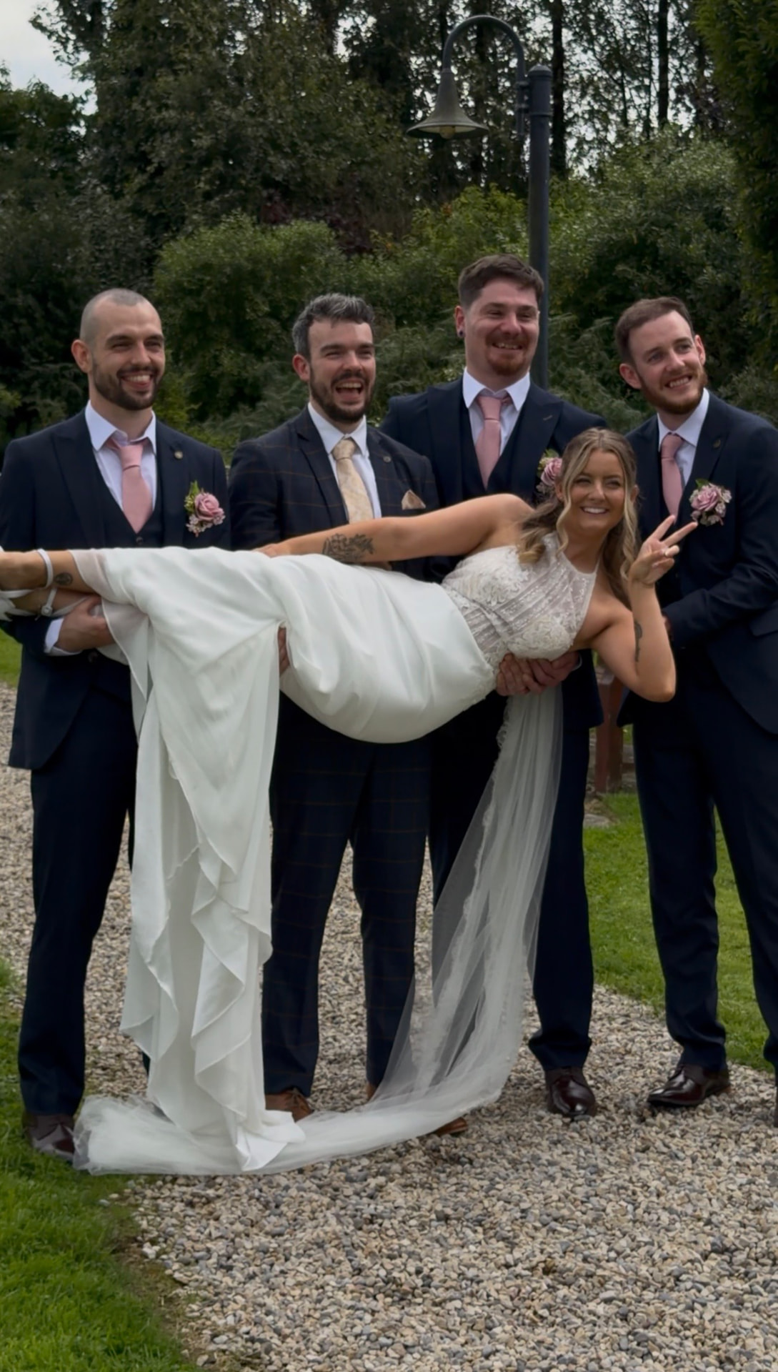 Niamh being lifted by the groomsmen in the gardens