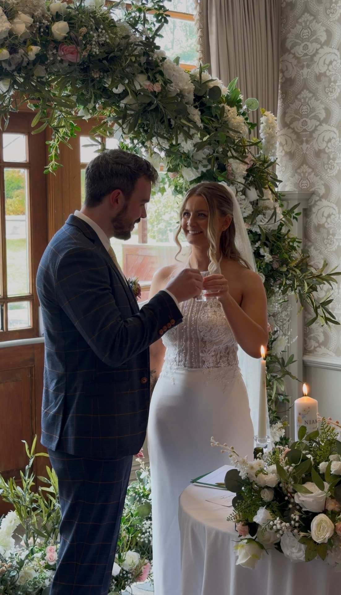 Niamh and Shane during their ceremony beneath a floral arch