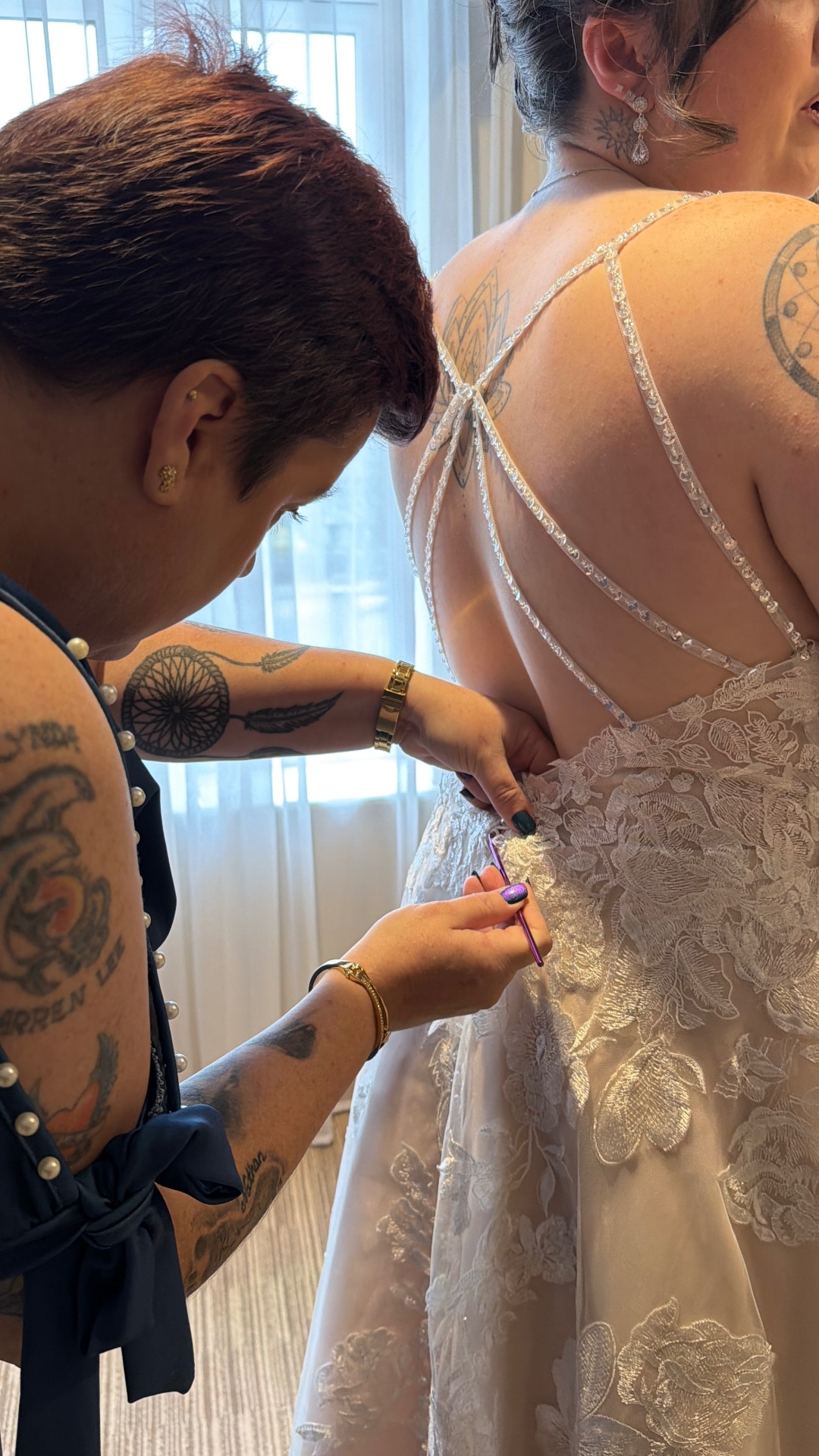 Lynda being helped into her lace wedding dress