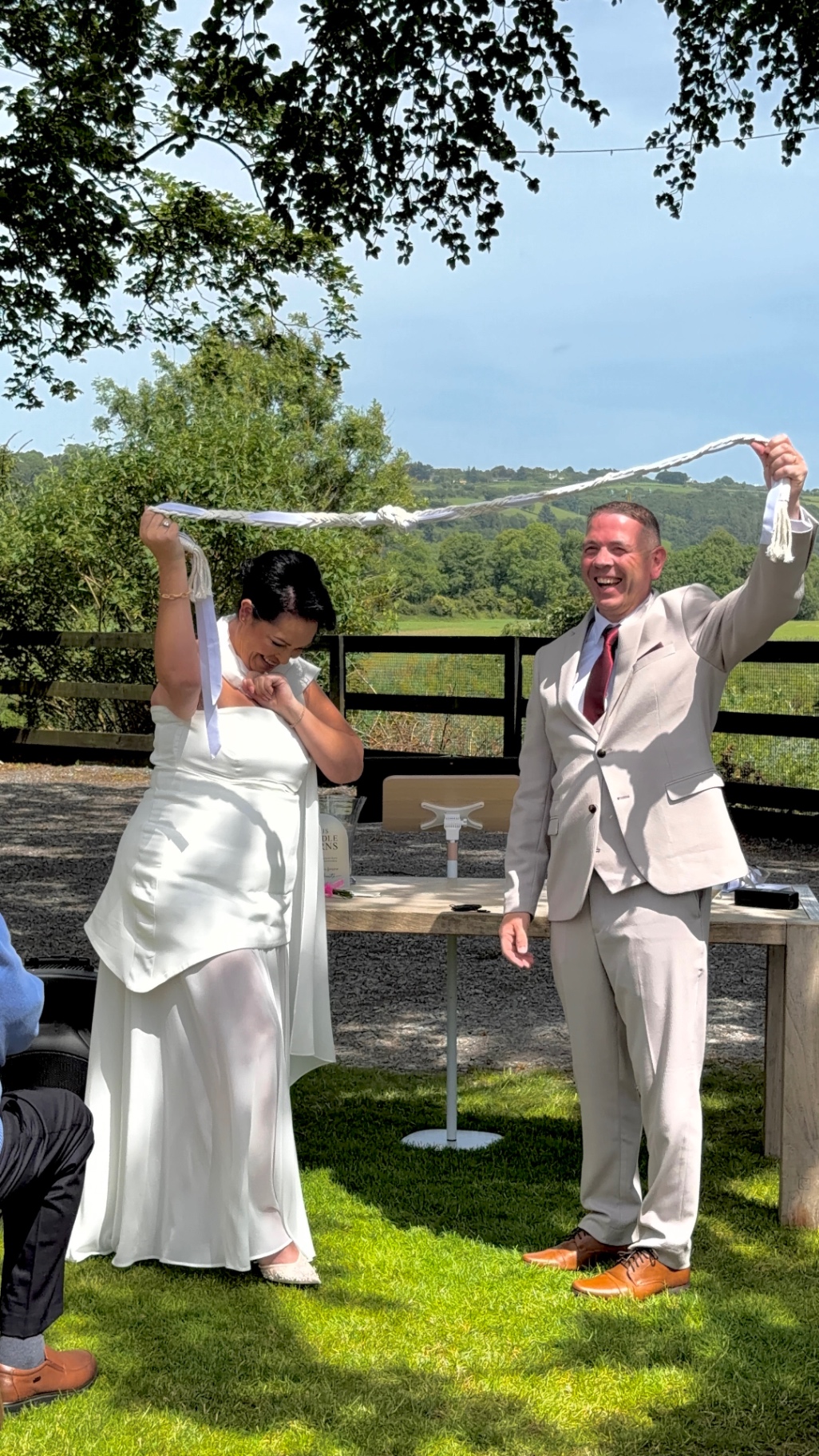 Yvonne and Trevor lifting the handfasting cord after their ceremony